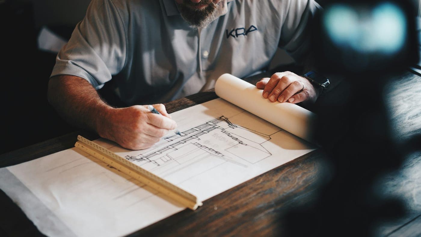 Architect sketching floor plans on drafting paper
