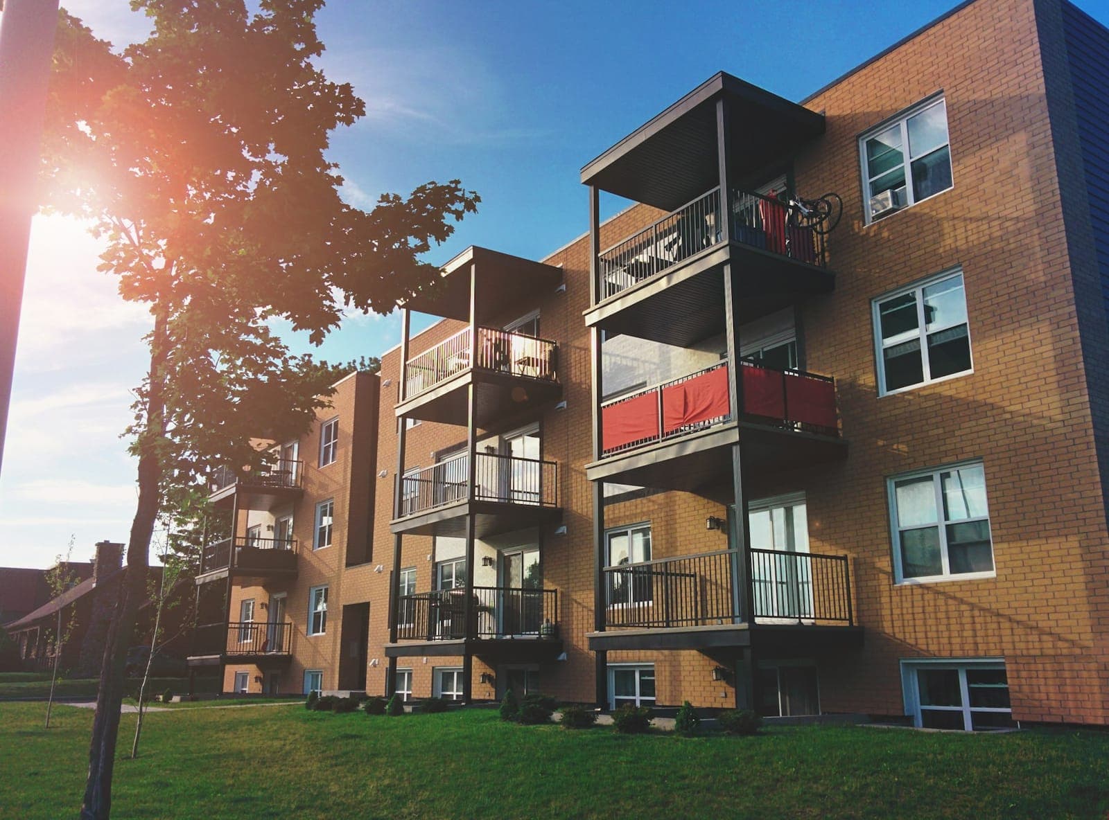 Warm brick apartment building with stacked balconies in evening light
